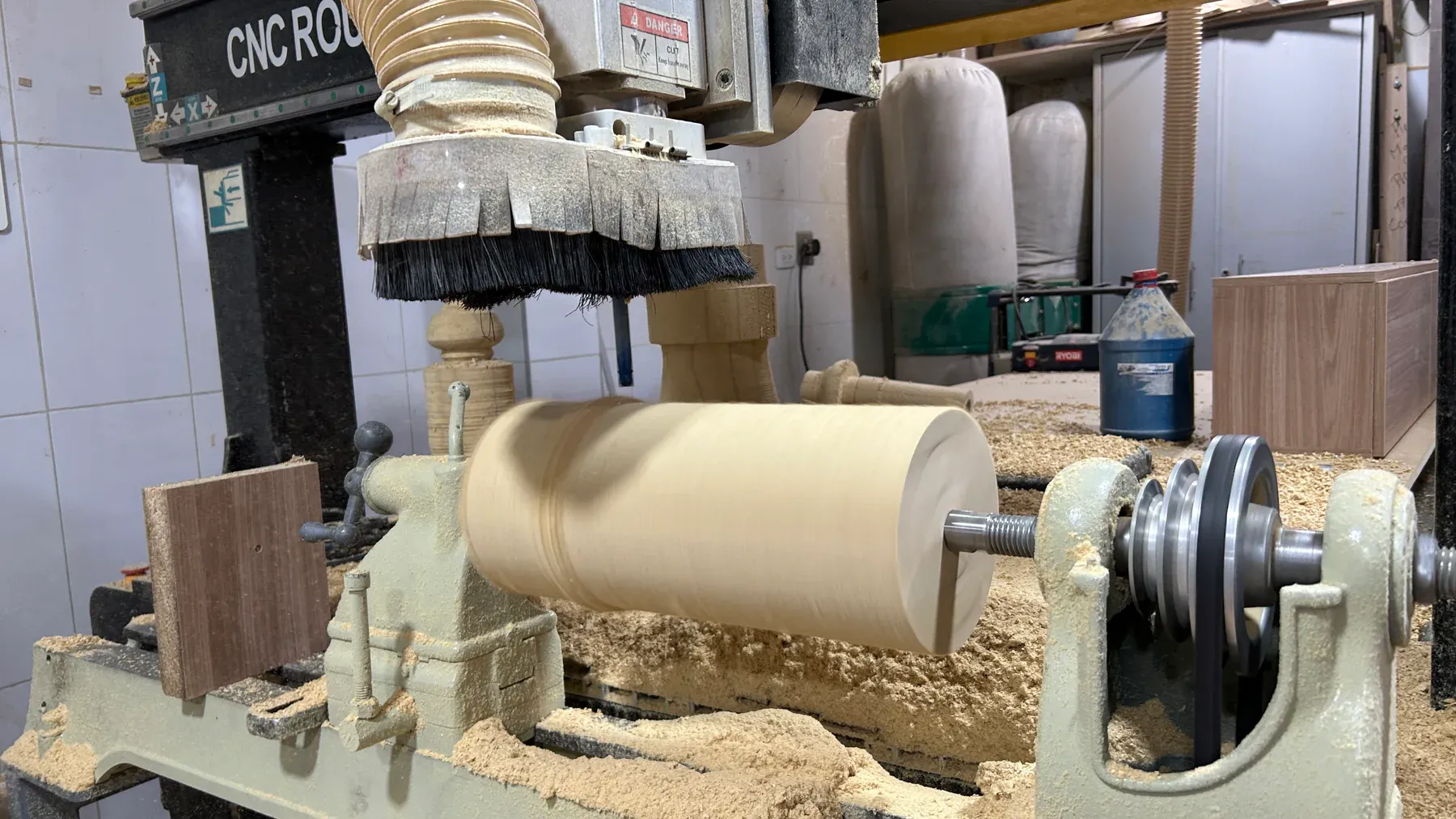 Pieza de madera sujeta entre centros en el sistema rotativo integrado al router CNC