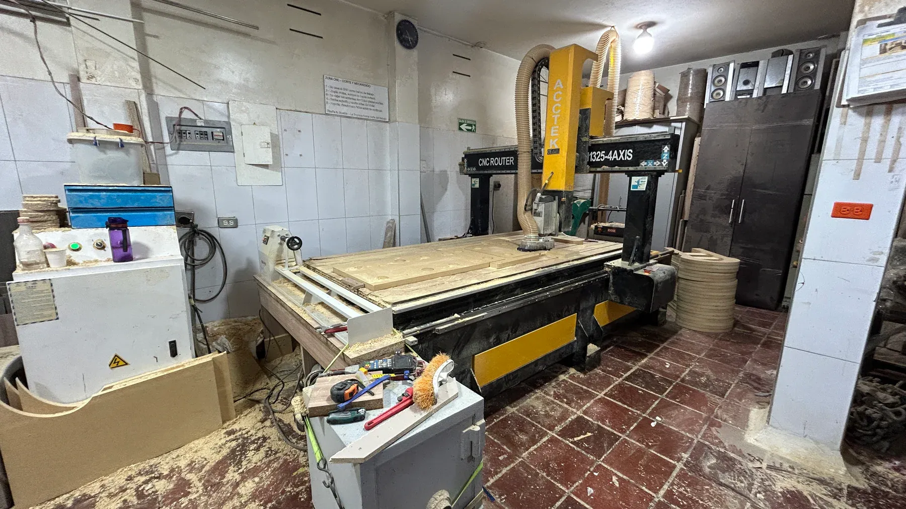 Tablero sobre la mesa del router CNC con contornos y piezas mecanizadas