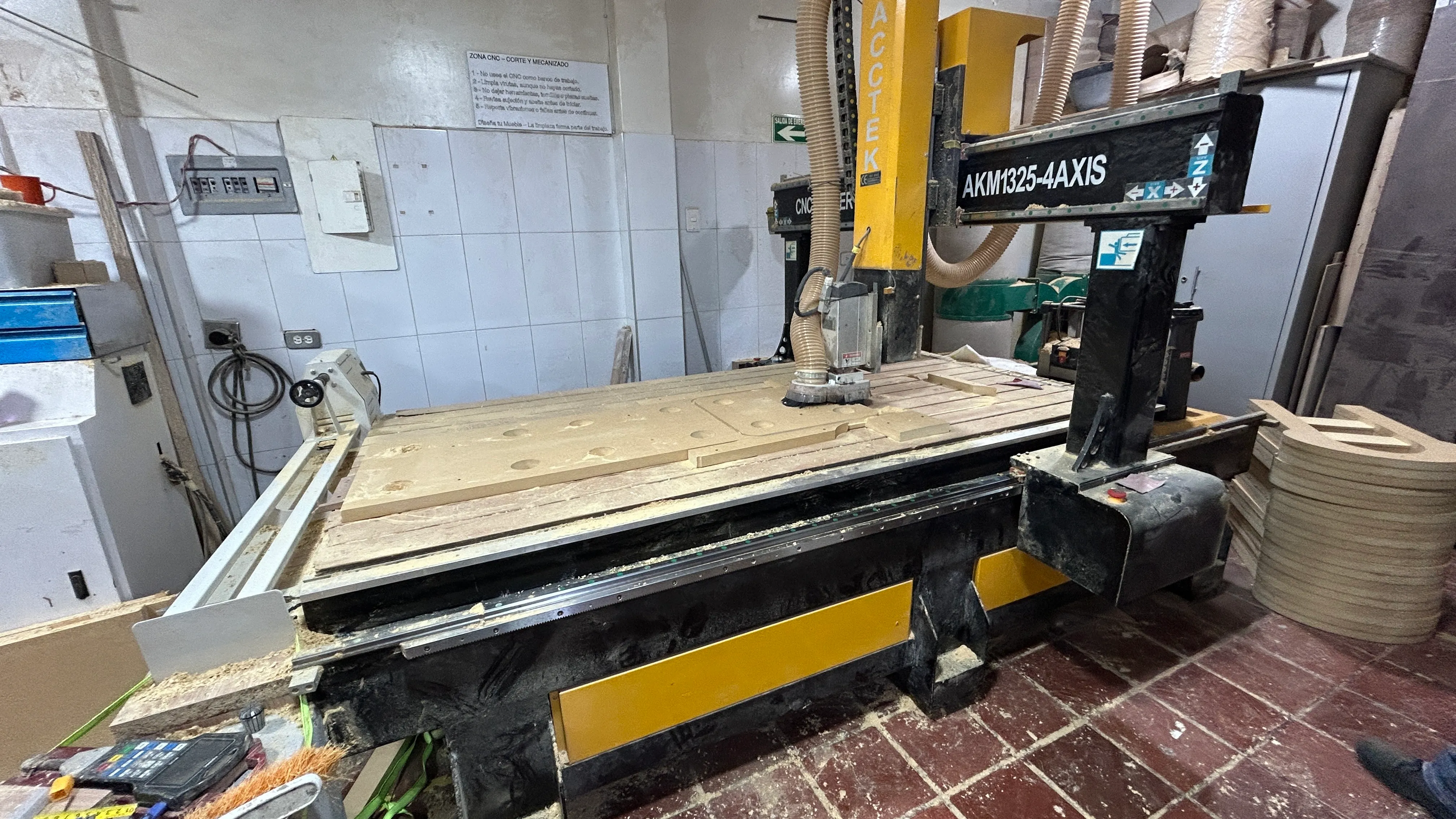 Router CNC instalado en el taller, con mesa de mecanizado y sistema de extracción de viruta
