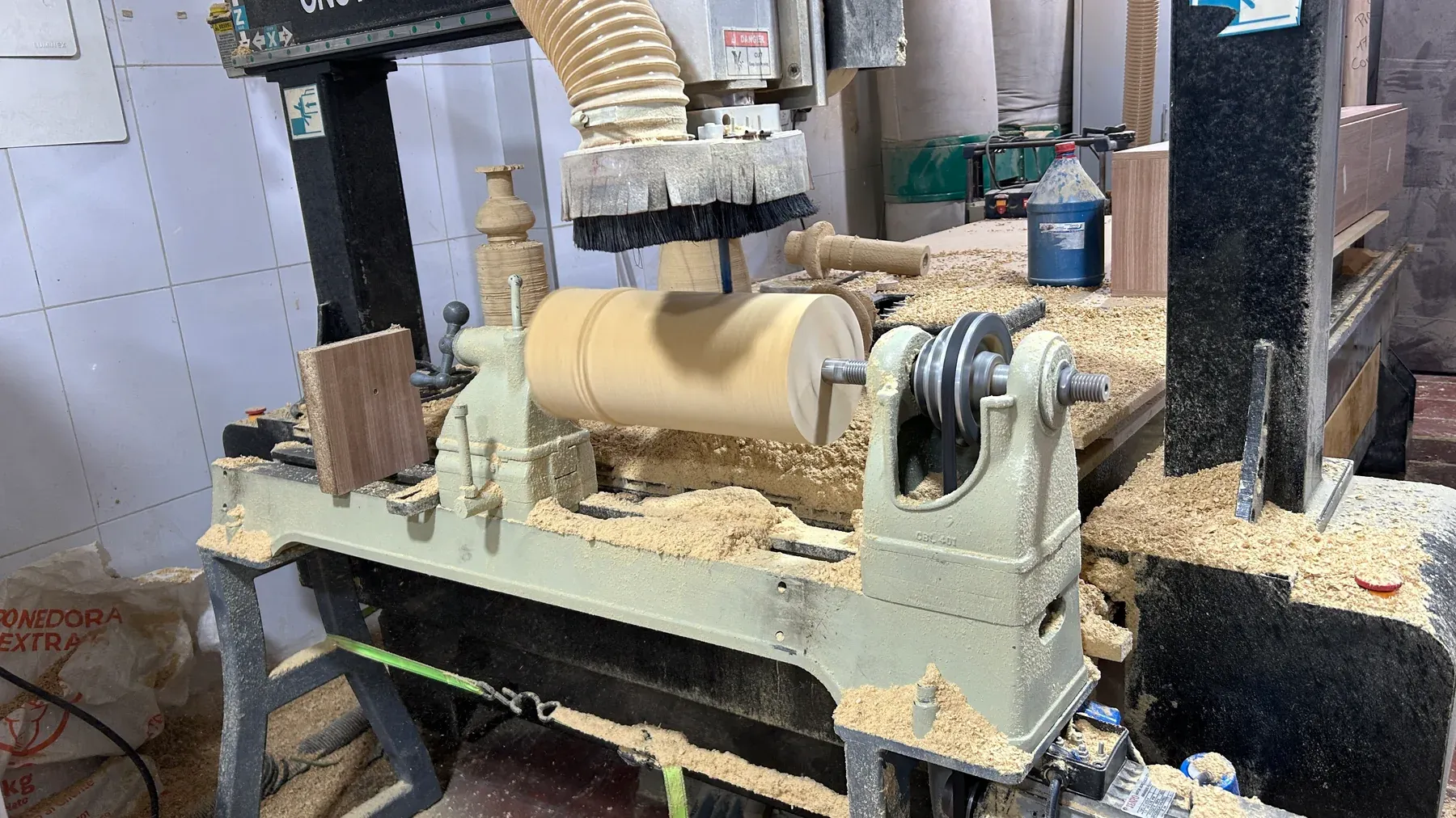 Pieza cilíndrica de madera girando en un torno integrado con router CNC